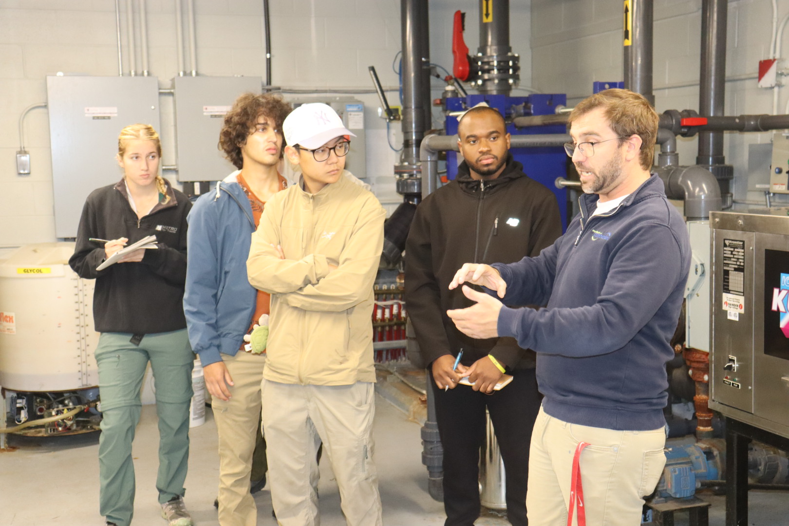 A man gives directions to a group of people on the use of geothermal power at the community centre in Springhill.